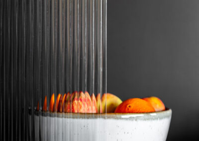 Bowl of fruits behind halfinchreed glass