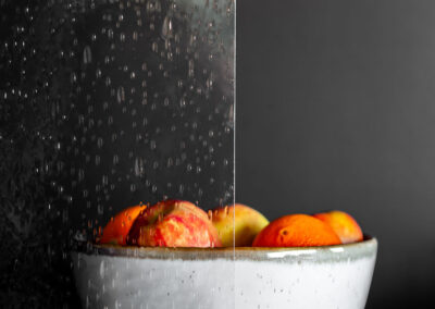 Bowl of fruits behind raindrop glass