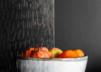 Bowl of fruits behind water-like textured glass