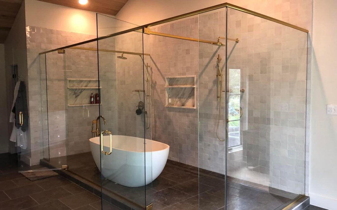 A glass shower with a tub and a shower